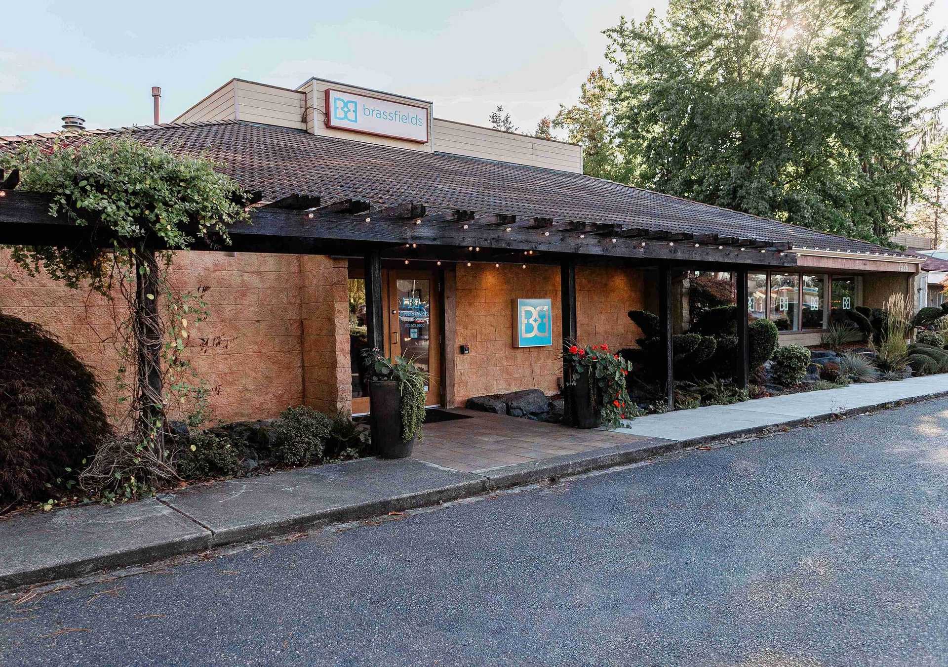 Exterior view of a store called Brassfield's with a rustic design and greenery surrounding the entrance.